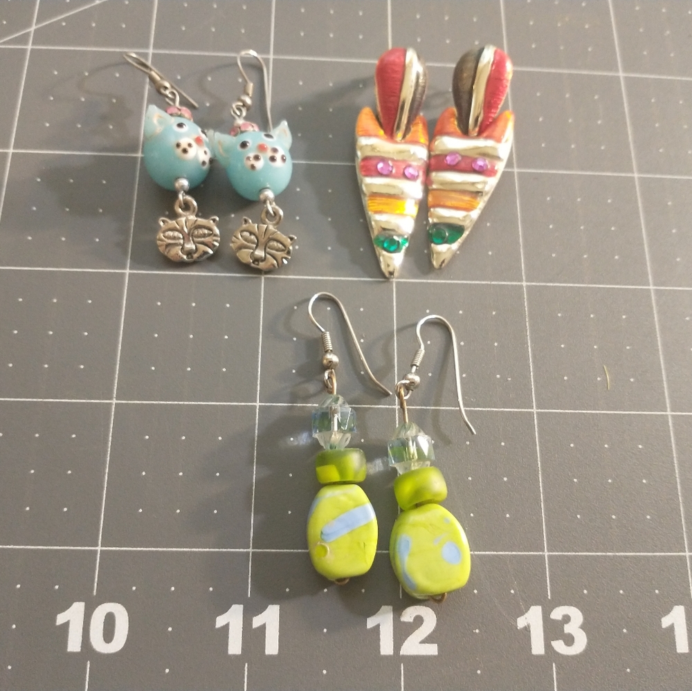 Three pairs of eclectic dangle earrings each about two inches long